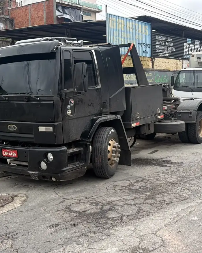 Caminhão baú rebocado em rua estreita